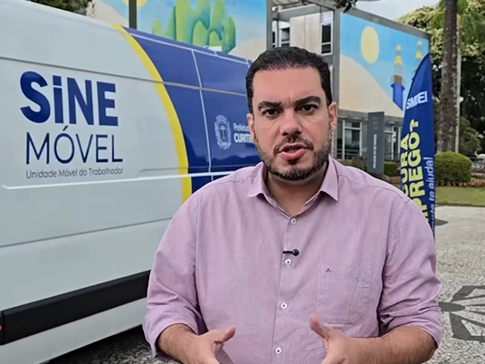 O prefeito interino de Curitiba, Paulo Martins, ao lado de uma van do SINE Móvel durante a manifestação dos moradores de rua.