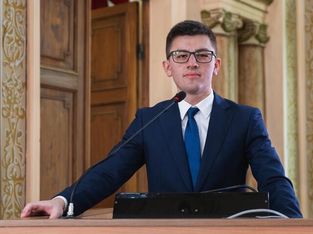 O vereador do NOVO, Guilherme Kilter, que apresentou um projeto para aumentar as punições contra pichação e vandalismo em Curitiba, aparece de pé na tribuna da Câmara.