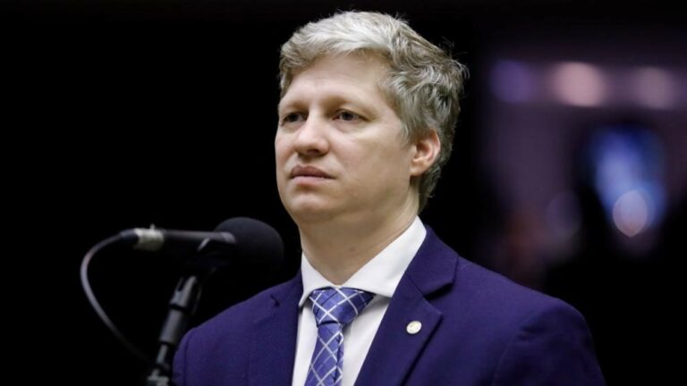 Na imagem da matéria “Câmara Pode Suspender Marcel van Hattem Nesta Terça”, Marcel aparece no plenário da Câmara dos Deputados.
